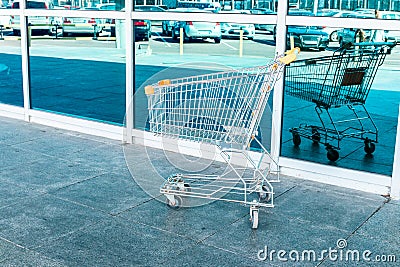 Online Shopping and delivering concept. Shopping cart near shop on city street Stock Photo