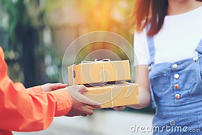Online shopping, Woman receiving parcel from delivery man bringing some package at the home, shipping and postal service concept Stock Photo