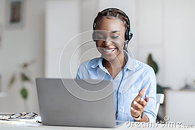 Online Tutoring. Black Female Tutor In Headset Having Video Conference With Laptop Stock Photo