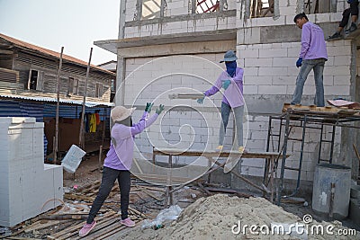 Onstruction workers installing roof tiles Editorial Stock Photo