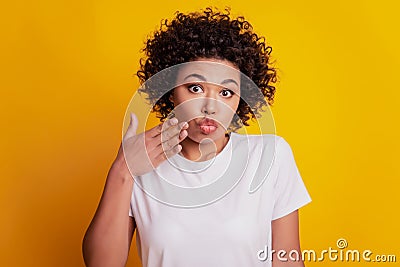 Oops beautiful woman surprised face palm lips look camera on yellow wall Stock Photo