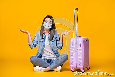 Oops. Full body photo of pretty young lady sitting floor unhappy missed flight rolling bag travel airport quarantine Stock Photo