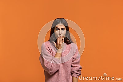 Oops sorry. Portrait of beautiful female covering her mouth in I made an error, omg sign gesture and regrets what happened. Wears Stock Photo