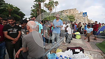 Oorlogsvluchtelingen dichtbij tenten op de overzeese waterkant Meer dan half zijn migranten van Syrië Oorlogsvluchtelingen dichtbij tenten op de overzeese waterkant Meer dan half zijn migranten van Syrië