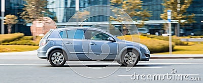 Opel Astra H fast speed driving on the asphalt road, side view. Silver hatchback in motion on the city highway Editorial Stock Photo