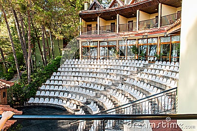 Open-air amphitheater for evening performances at a coastal hotel, surrounded by lush vegetation Stock Photo