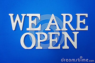 We are Open alphabet letters on blue background Stock Photo