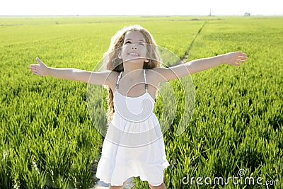 Open arms little happy girl green meadow field Stock Photo