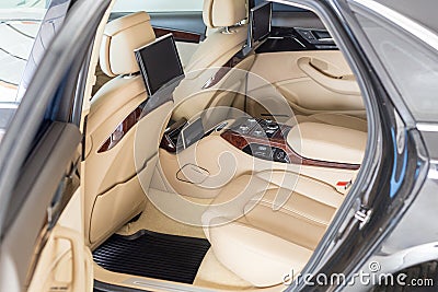 Open back door of business class car. Rear seat of modern luxury vehicle. Interior of limousine with entertainment Stock Photo