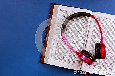 Open Bible on a headphones on religious audiobook Stock Photo