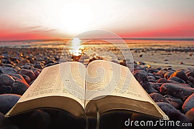 Open bible spiritual light on seashore Stock Photo