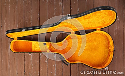 Open black and yellow acoustic guitar hard case on a wooden background Stock Photo