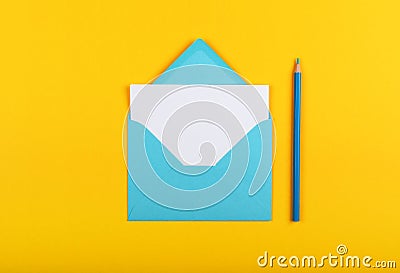 Open blue paper envelope over yellow Stock Photo