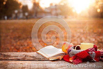 Open book, apple and tea cup with warm scarf Stock Photo