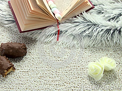 An open book and chocolates on the table. Stock Photo