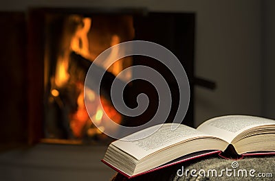 Open book by fireplace. Stock Photo