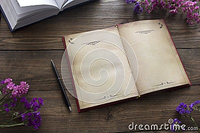 Open book , flowers and pen Stock Photo