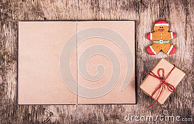 Open book, gingerbread man and gift box. Christmas surprise. Festive backgrounds. Stock Photo