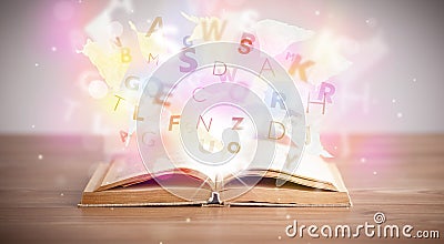 Open book with glowing letters on concrete background Stock Photo