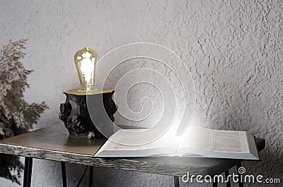 Open book Holy Bible on the table. Loft style lamp. In room. Desktop. Office. Stock Photo