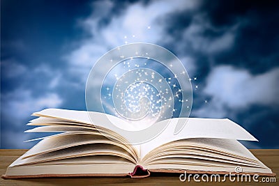 Open book with magic glowing on table. Fairy tale Stock Photo