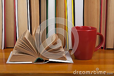 Open book, red cup hardback colorful books on wooden table. Back to school. Copy space for text. Education business Stock Photo