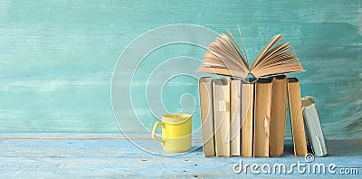 Open book on a row of old books and a cup of coffee. Reading, learning, education, literature topics Stock Photo