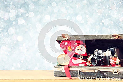 Open briefcase with old camera and christmas decoration over bokeh blurred background Stock Photo