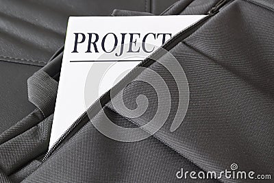 Open briefcase with some documents in it. A paper with the title PROJECT written on it. Stock Photo