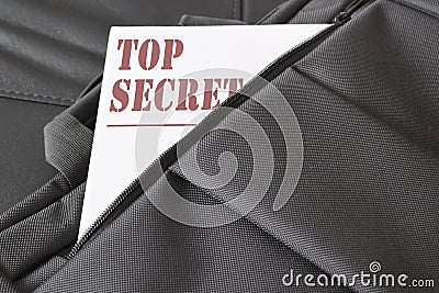 Open briefcase with some documents in it. A paper with the title TOP SECRET written on it. Stock Photo