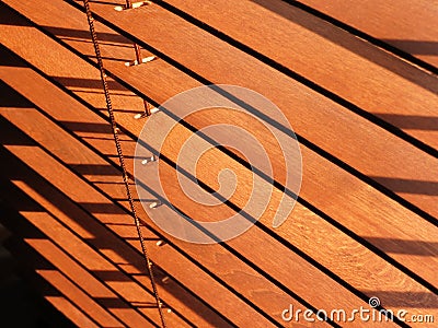 Open brown wooden blinds, with sunlight shining through Stock Photo