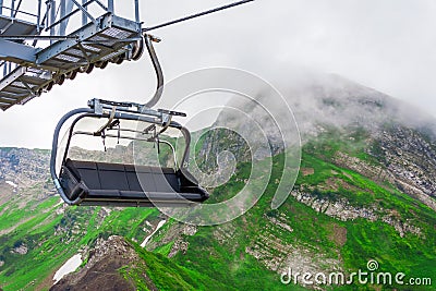 Open cabin lift cable car in the mountains in the clouds summer Stock Photo