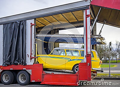 Open car hauler semi trailer for safety car transportation unloading retro vehicle Stock Photo