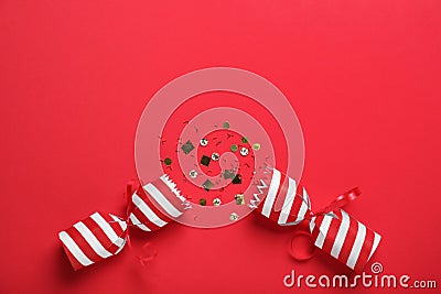 Open Christmas cracker with shiny confetti on red background, top view. Space for text Stock Photo