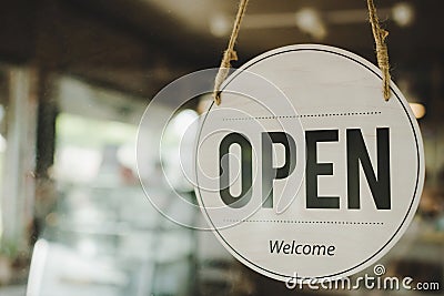 Open. coffee cafe shop text on vintage sign board hanging on glass door in modern cafe coffee shop Stock Photo