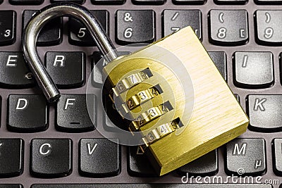 Open combination padlock on a laptop keyboard symbolizing data security Stock Photo