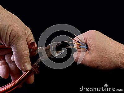 Open copper wires in a male hand. Electro wiring in hands, on a black background. Electrician Stock Photo