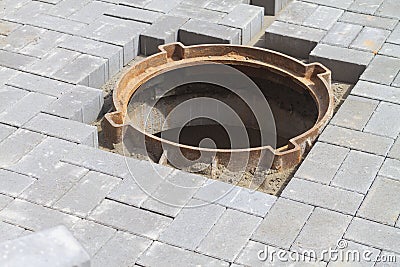 Open dangerous manhole of a sewer well on the sidewalk at the house Stock Photo