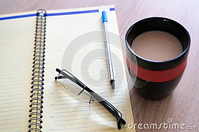 Open the diary a planner, a pencil and glasses on the table closeup Stock Photo