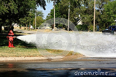 Open Fire Hydrant Gushing Water Into The Street Stock Photo