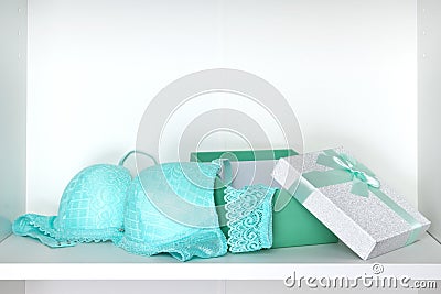 Open gift box with lingerie set on white shelf inside closet Stock Photo