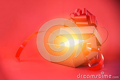 Open Gift Box rays light on red background red present box with red ribbon bow for Merry Christmas Holiday Happy new year Stock Photo