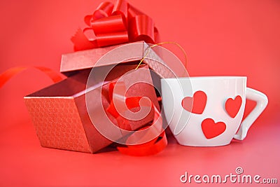 Open Gift Box and white Coffee cup with red heart Valentines day on red background Stock Photo