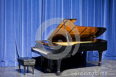 Open grand piano on stage with blue velvet cutain Stock Photo