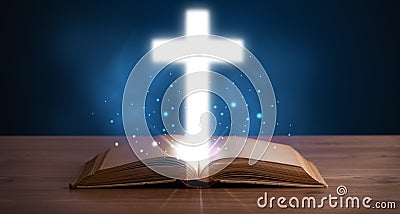 Open holy bible with glowing cross in the middle Stock Photo