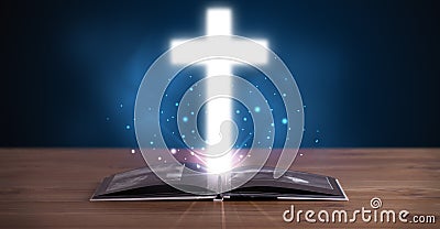 Open holy bible with glowing cross in the middle Stock Photo