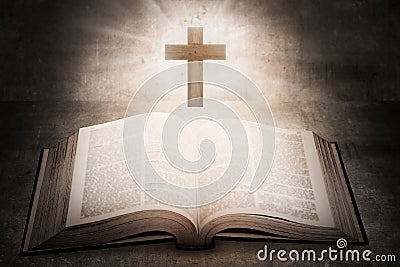 Open holy bible with wooden cross in the middle Stock Photo