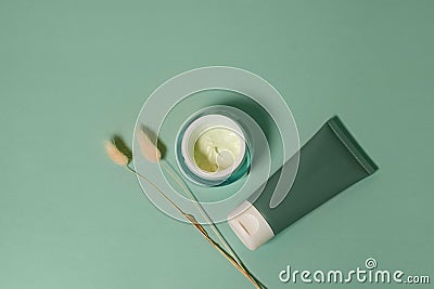 An open jar of face cream, a tube of hand cream, dried lagurus flowers Stock Photo