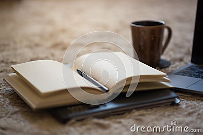 An open journal with pen and warm light illuminating blank pages Stock Photo