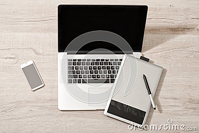 Open the laptop, graphics tablet and smart phone on a light table, top view Stock Photo